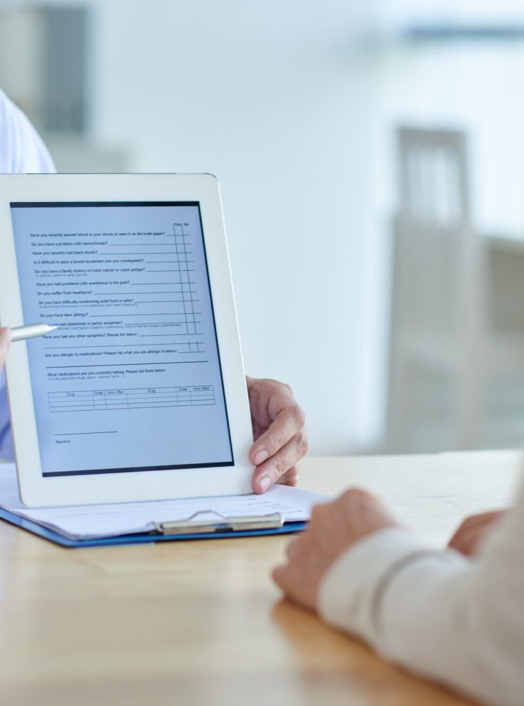 Doctor with Digital Tablet Close-up shot of physician pointing at screen of digital tablet, female patient listening to him with concentration
